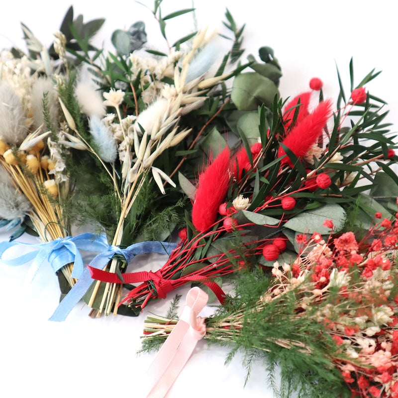 Bouquets of dried flowers with red and green elements on a white background