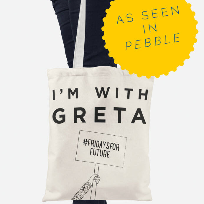 A person holding a white recycled fabric tote bag with the text 'I'm WITH GRETA' printed on it, along with the hashtag '#Fridaysforfuture' and the Peebble brand logo.