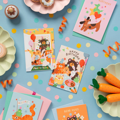 Collection of colourful birthday cards with cartoon animals on a blue background with confetti and party supplies.