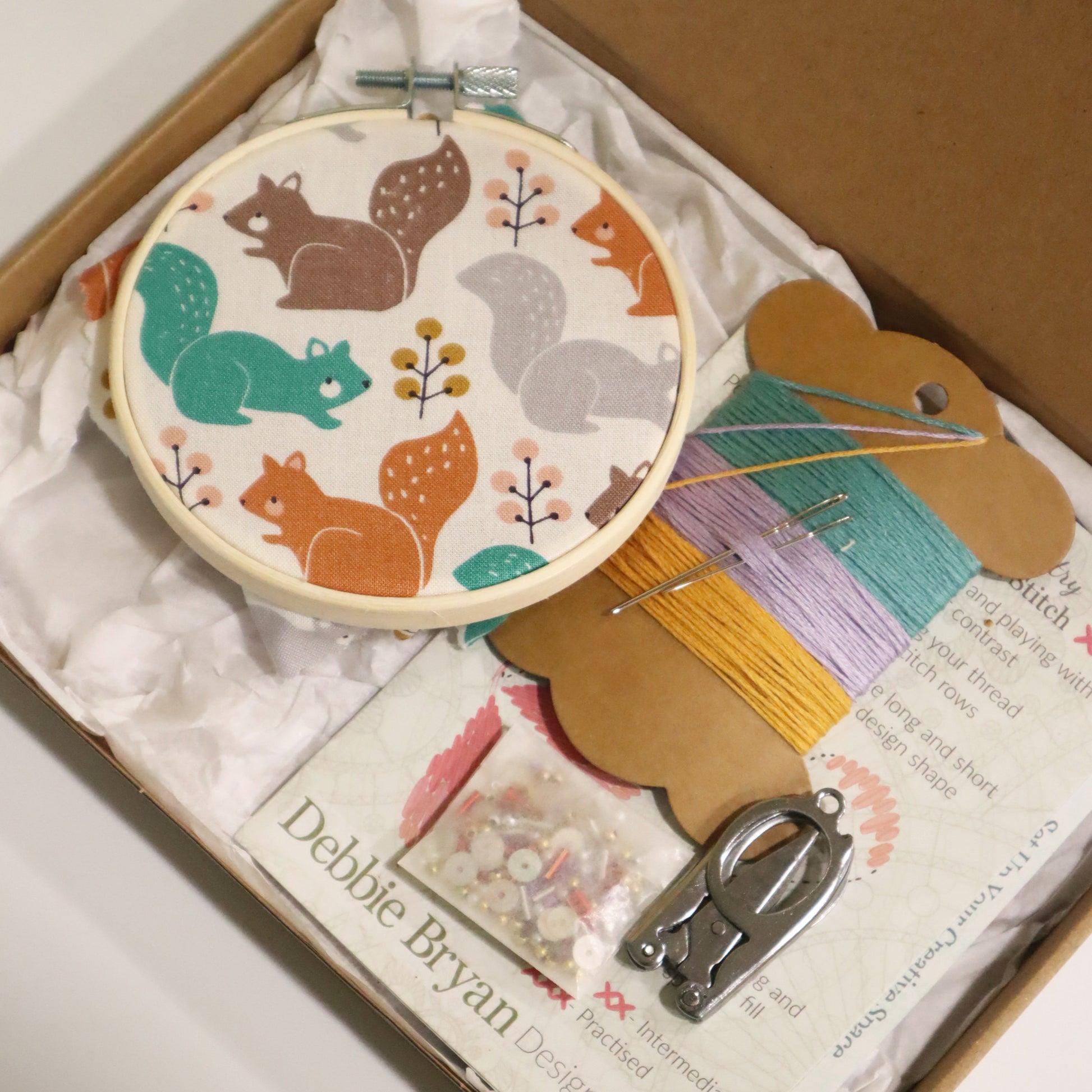 Embroidery hoop with animal pattern in a box with sewing supplies
