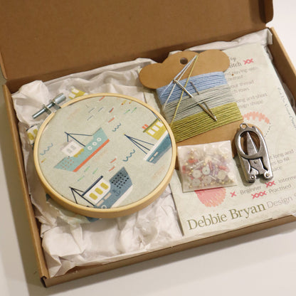 Embroidery kit with hoop, thread, and tools in a box, featuring Debbie Bryan stitch guide.