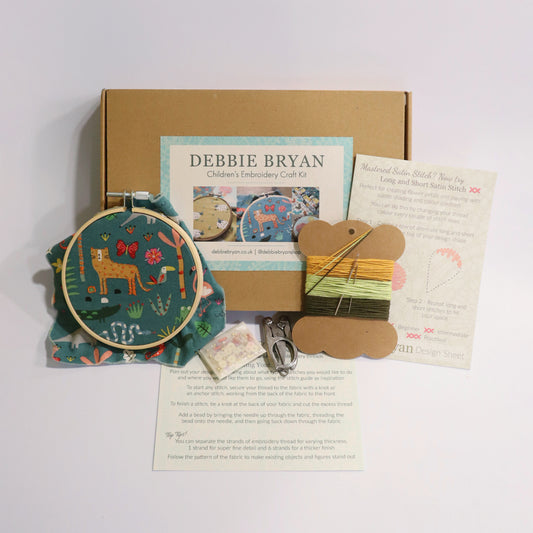 Jungle themed embroidery craft kit with hoop, thread, and instructions on a white background