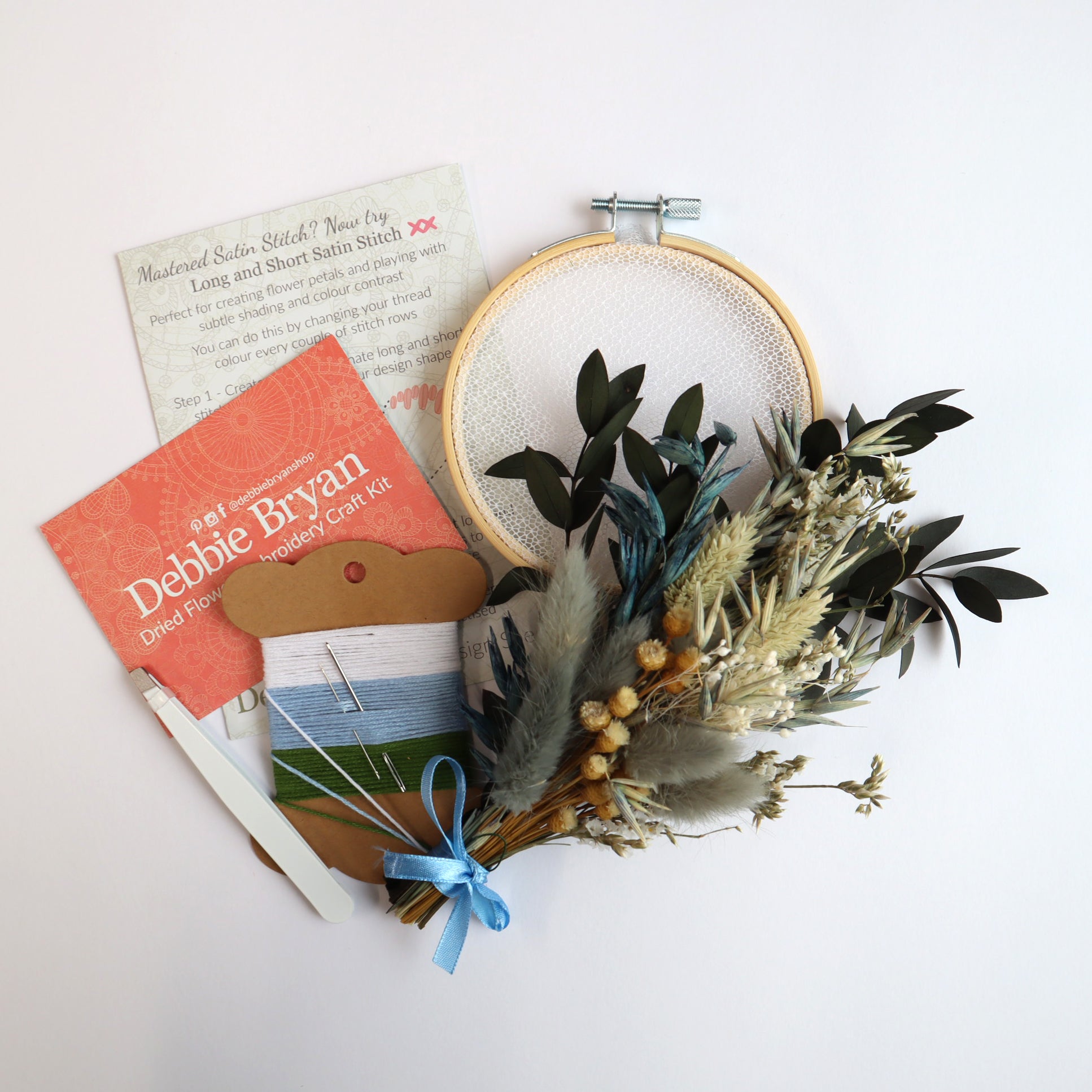 Contents of a dried flower embroidery craft kit which includes Nottingham Lace tulle in an embroidery hoop, dried flower bunch, embroidery threads and how-to instructions