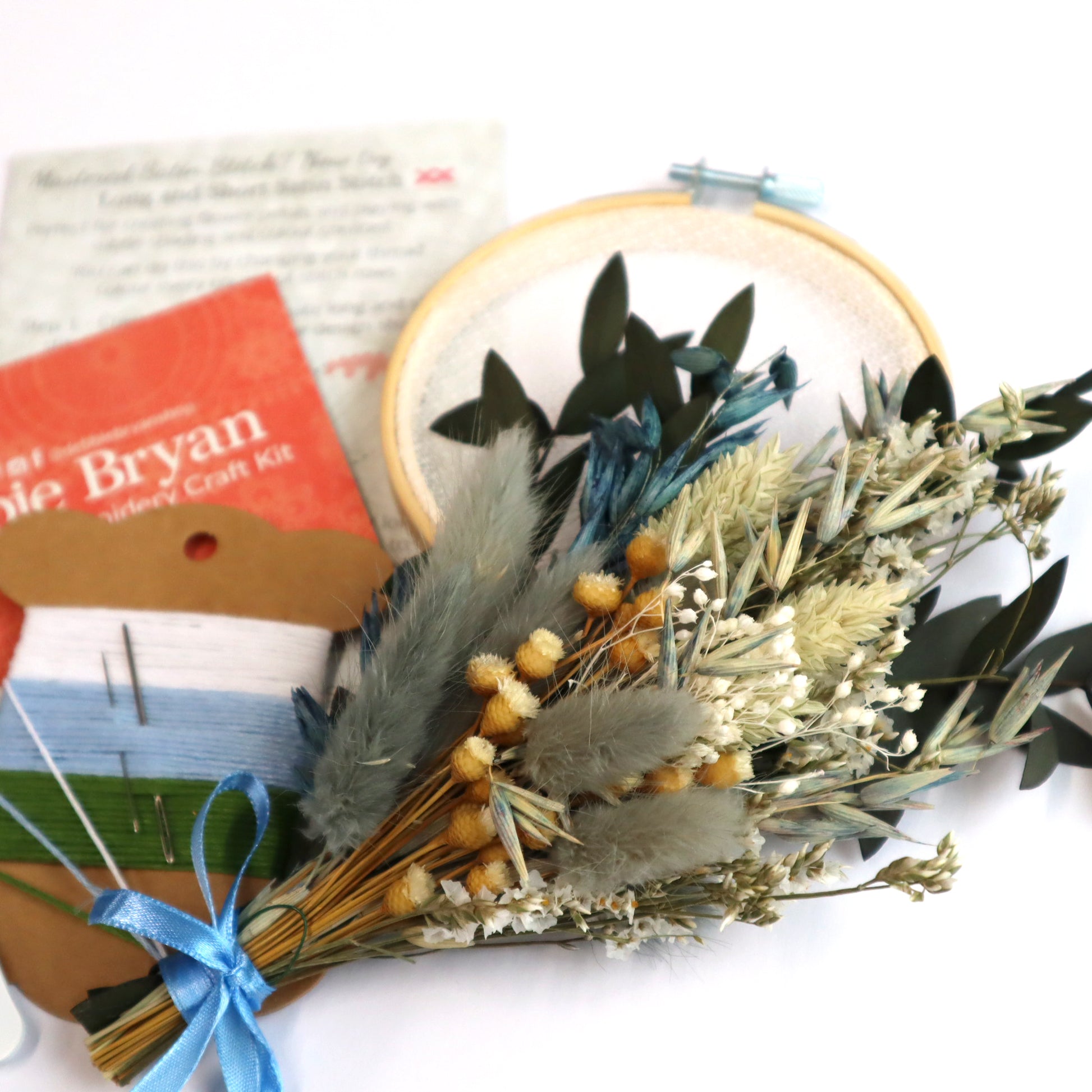 Green, white and blue dried flower bunch tied with a blue bow