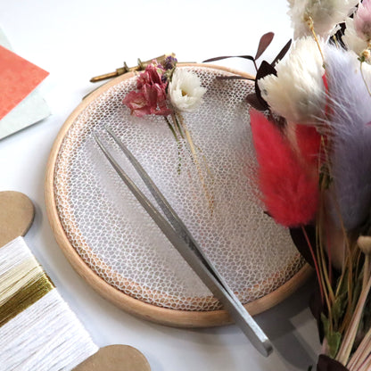 Nottingham Lace tulle in an embroidery hoop with dried flower woven into the fabric