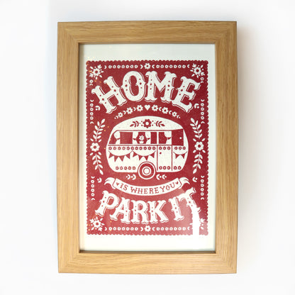 Framed print with 'Home is where your park it' text and graphic on a red background.