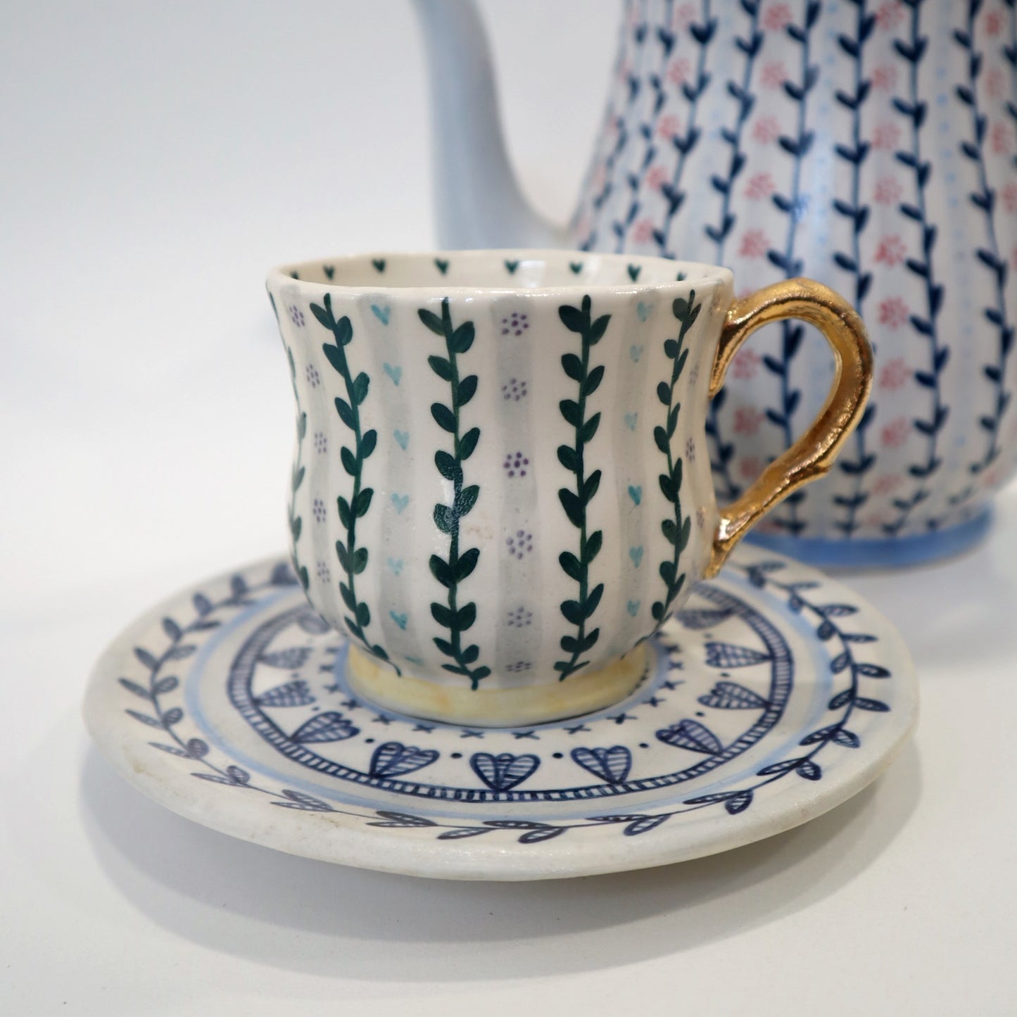 Patterned cup and saucer with gold handle