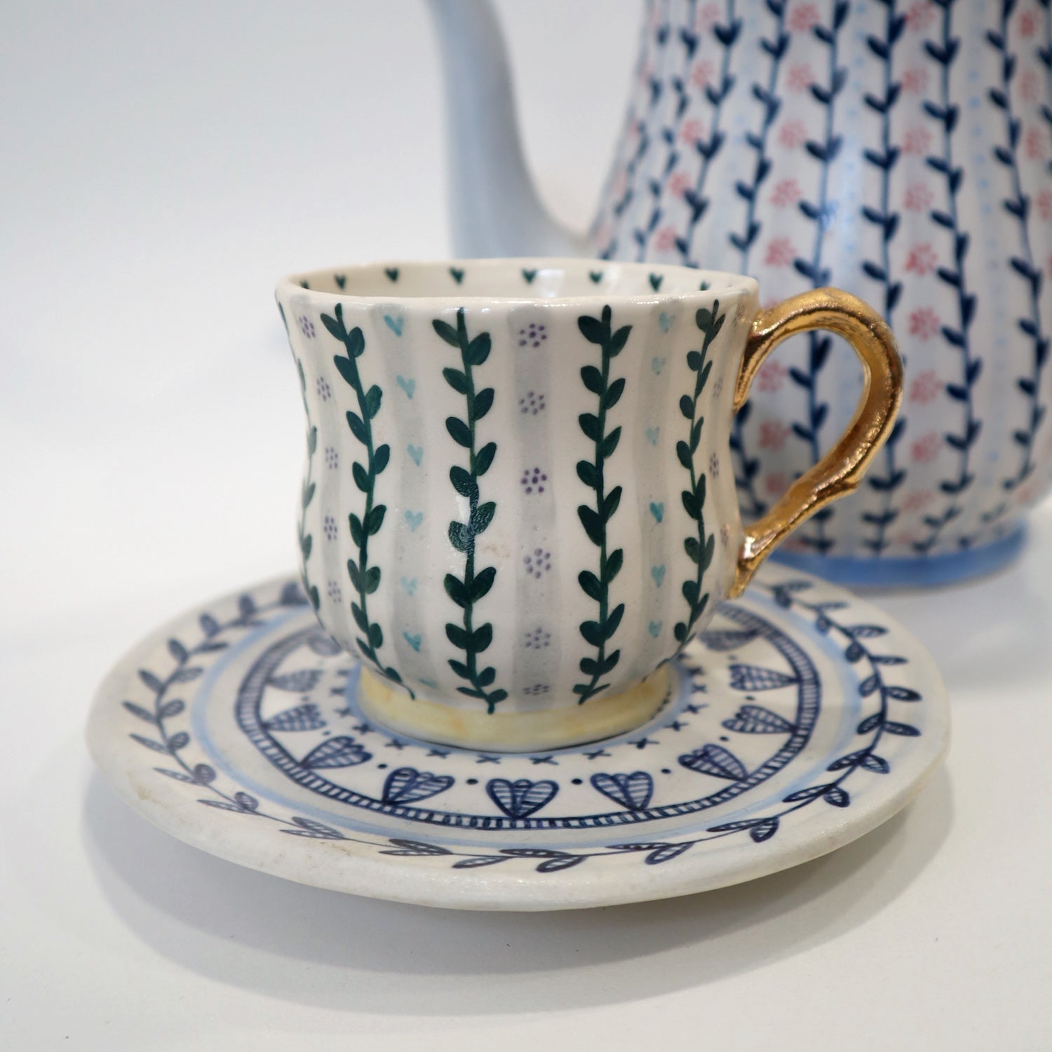 Patterned cup and saucer with gold handle