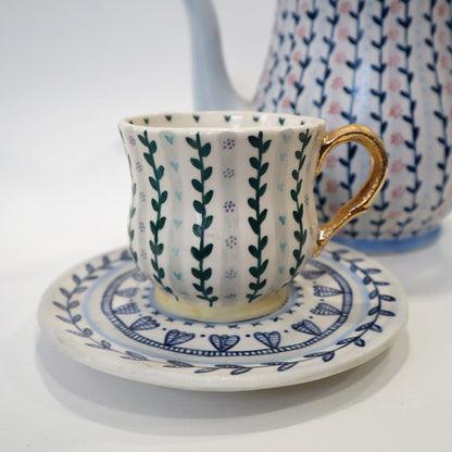 Patterned cup and saucer with gold handle