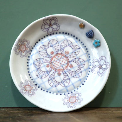 Decorative ceramic plate with floral patterns on a green background