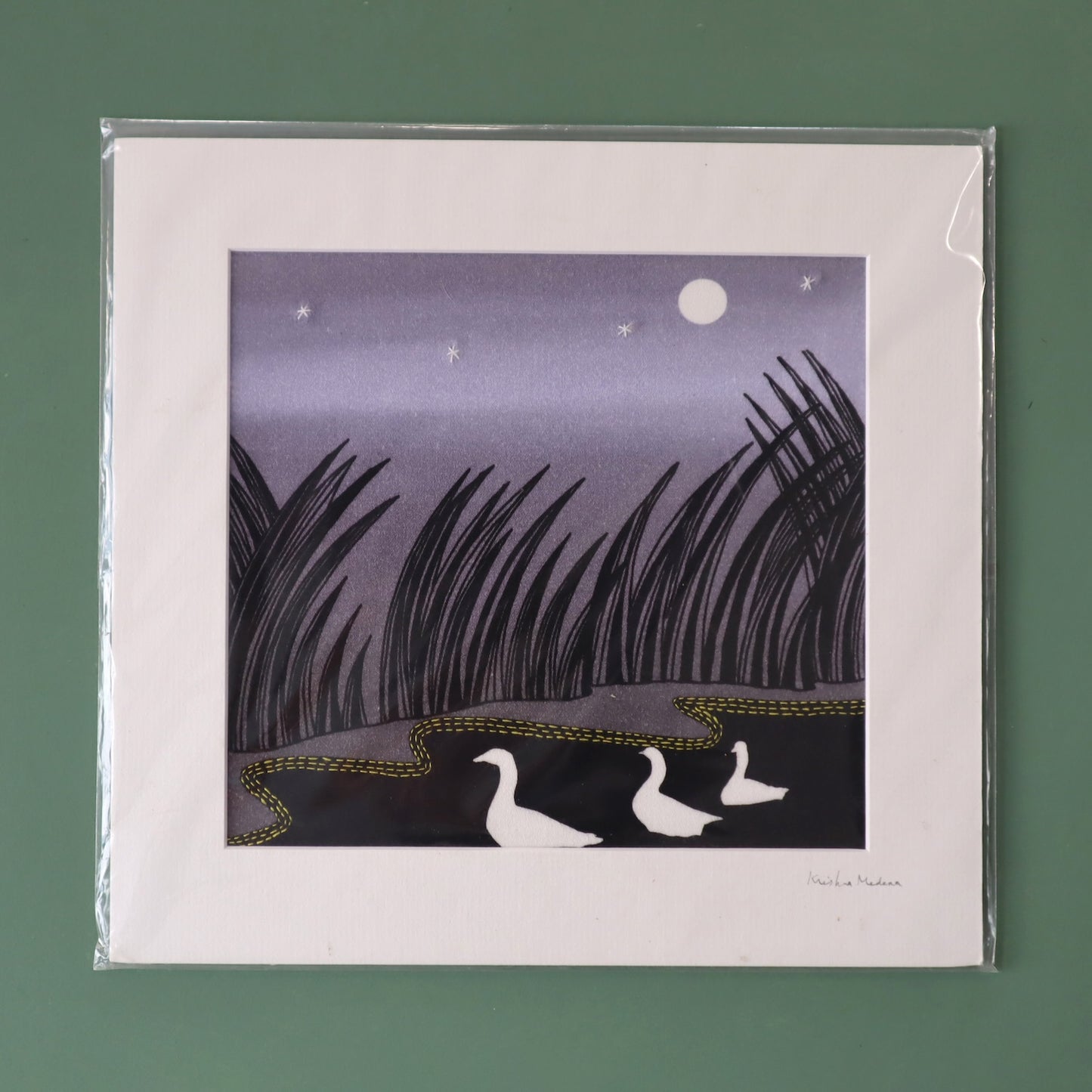 Packaged artwork of two ducks under a moonlit sky with reeds on a green background