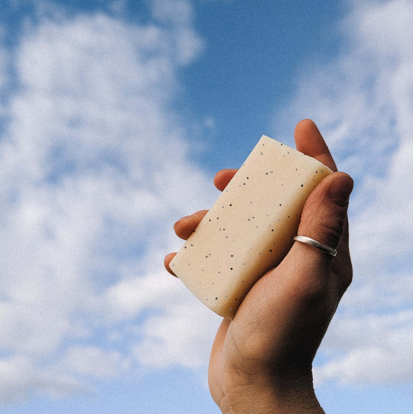 A hand holding a bar of soap to the sky