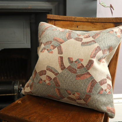 Decorative pillow with geometric pattern on a wooden chair