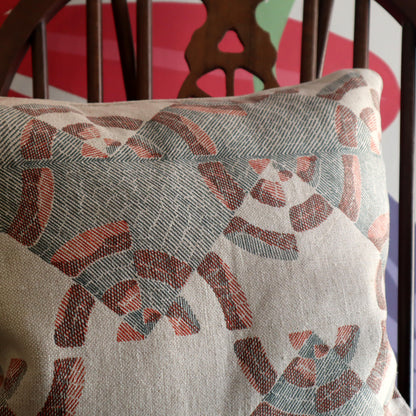 Patterned cushion on a chair with a colourful background