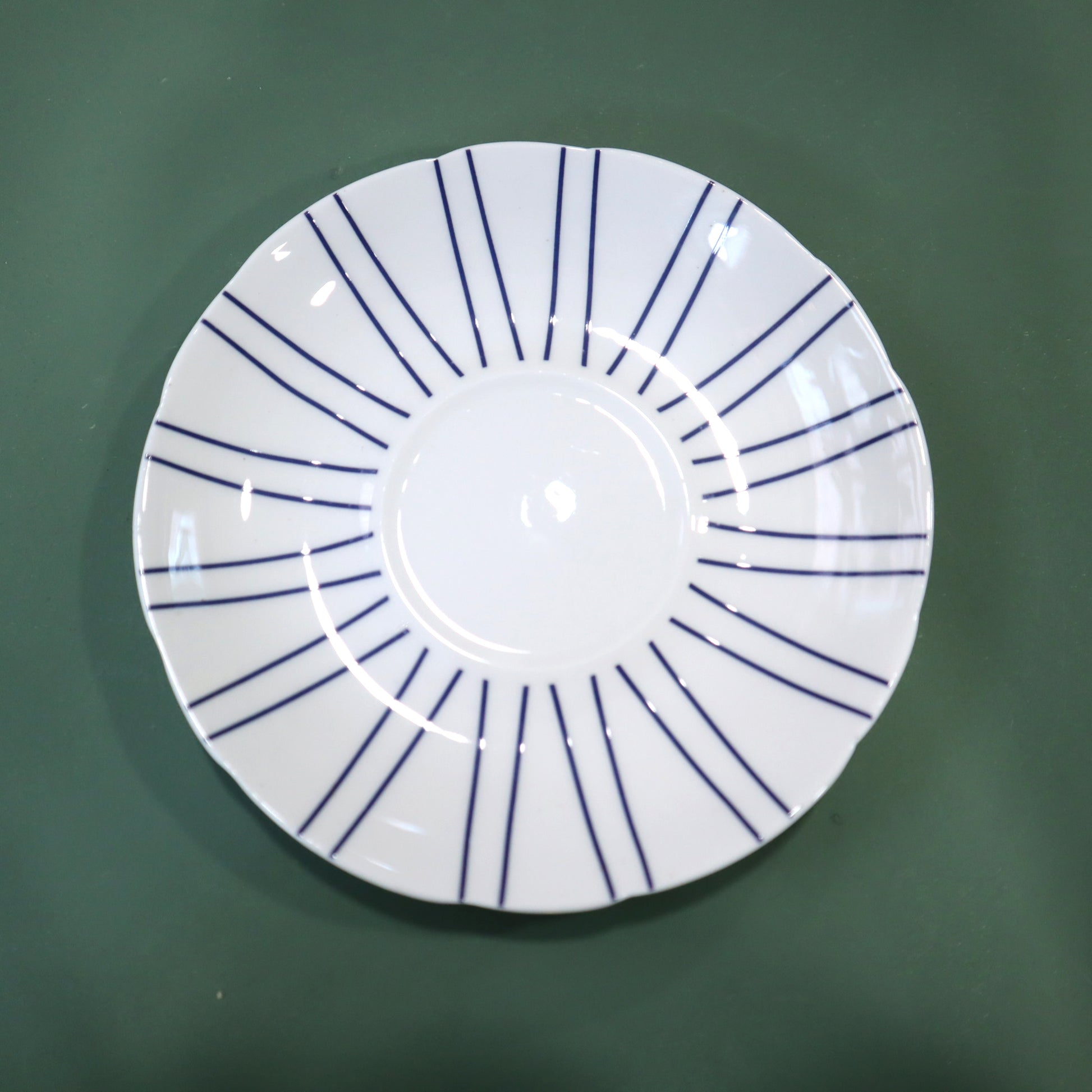 White plate with blue lines on a green background