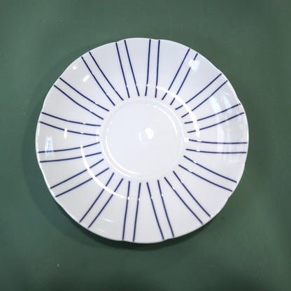 White plate with blue lines on a green background