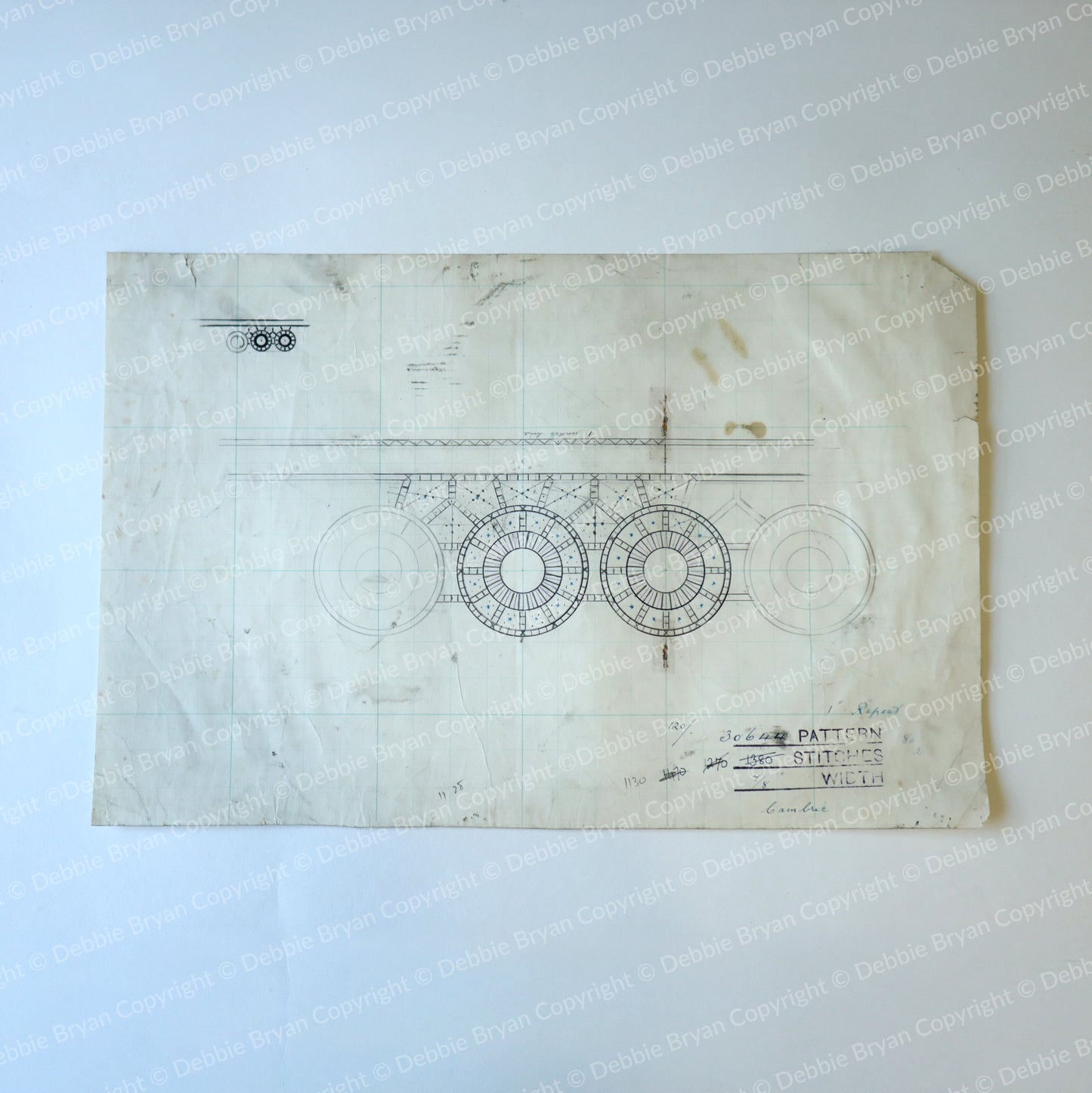 Vintage blueprint-style design on a textured surface with visible wear.