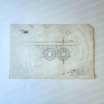 Vintage blueprint-style design on a textured surface with visible wear.