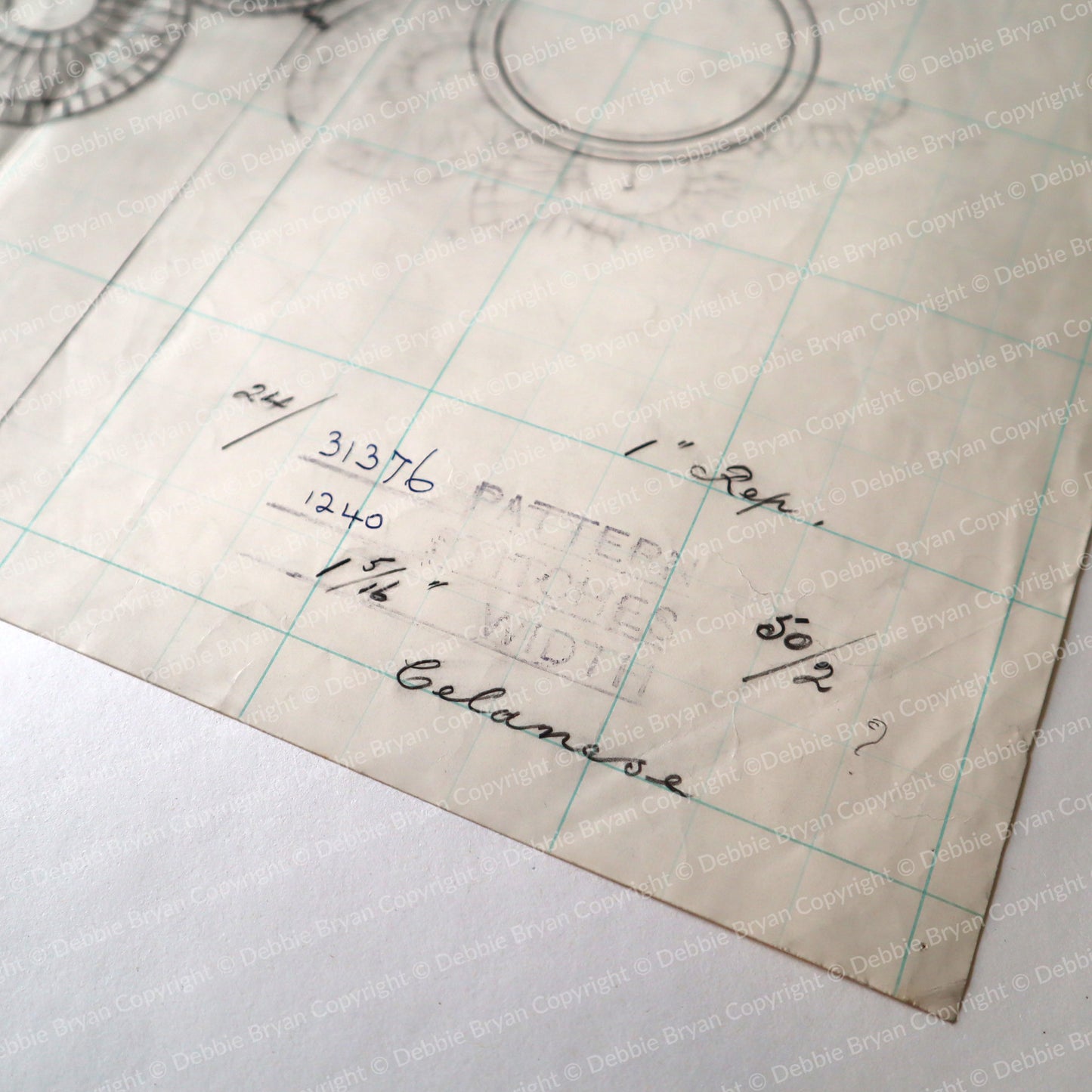Vintage sewing pattern paper with grid and measurements on a white background