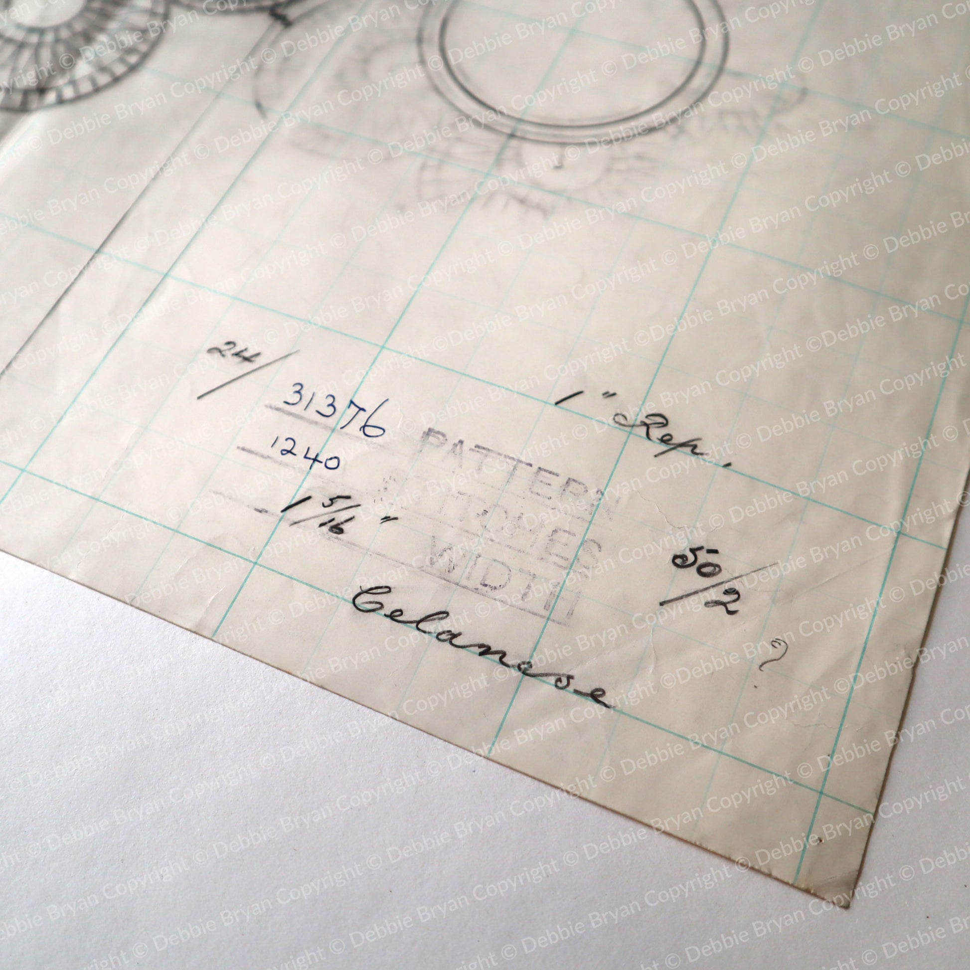 Vintage sewing pattern paper with grid and measurements on a white background