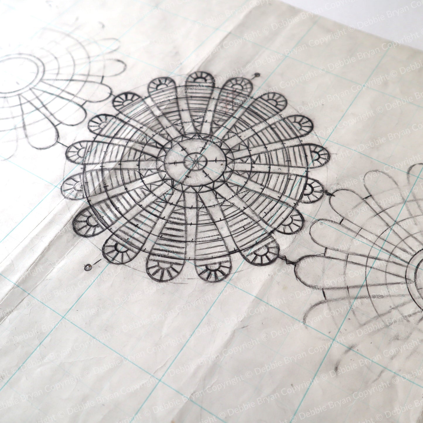 Detailed black line drawing of a mandala on grid paper