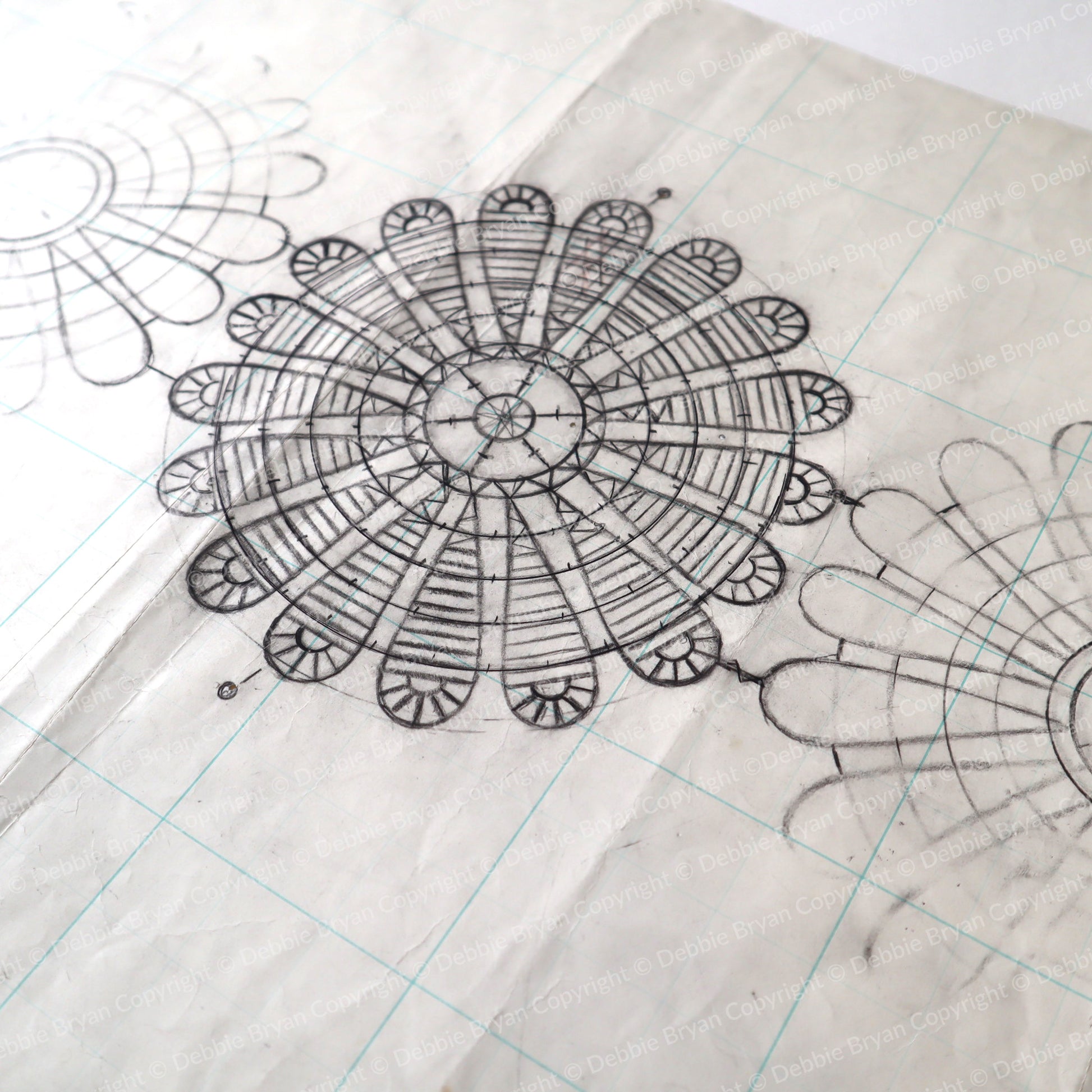 Detailed black line drawing of a mandala on grid paper