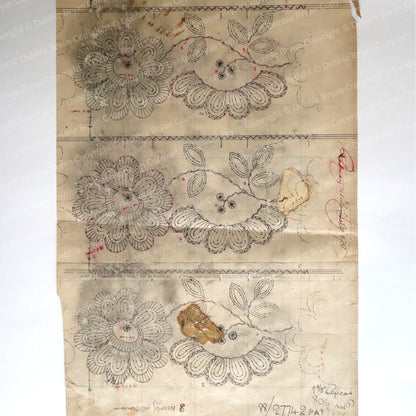 Sheet of paper with floral lace designs on a plain background