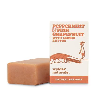 Peppermint and pink grapefruit soap packaging sitting next to a bar of soap