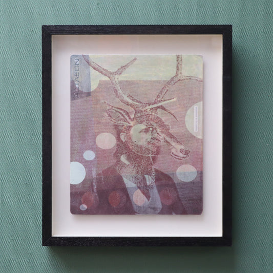 Framed artwork featuring a suited man with stags head