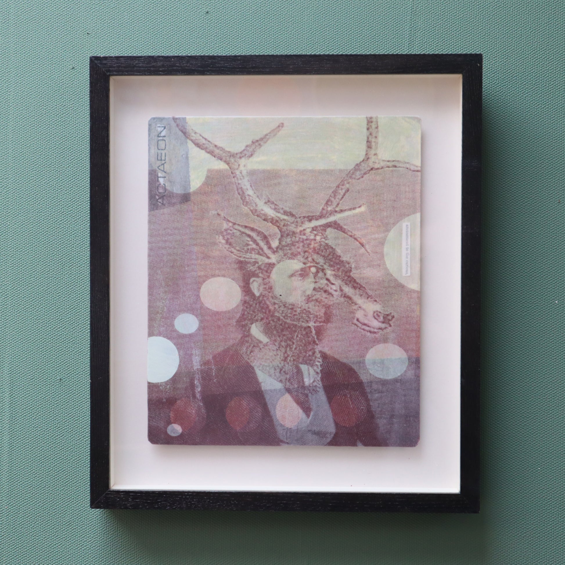Framed artwork featuring a suited man with stags head