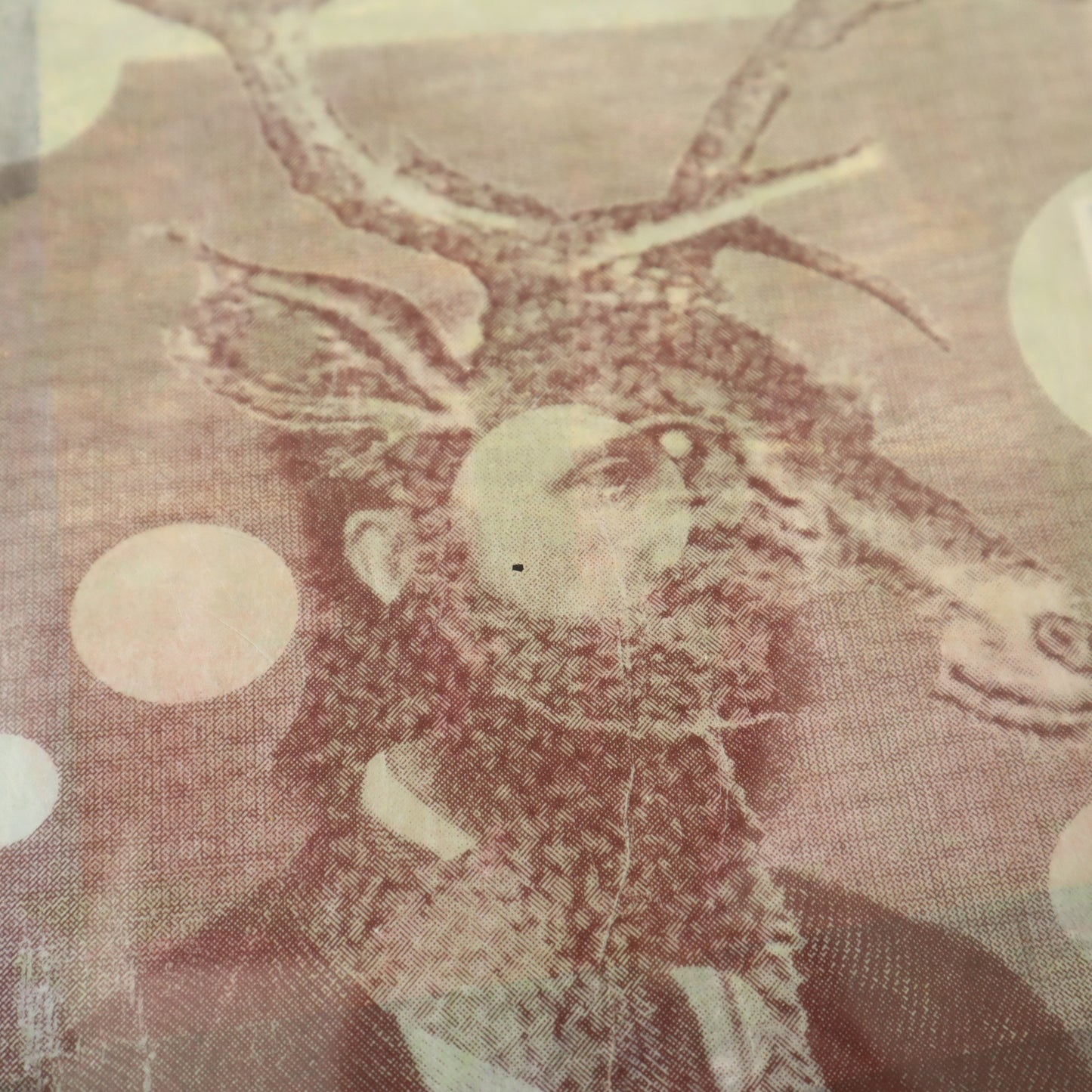 Decorative stag figure with antlers on a textured fabric background