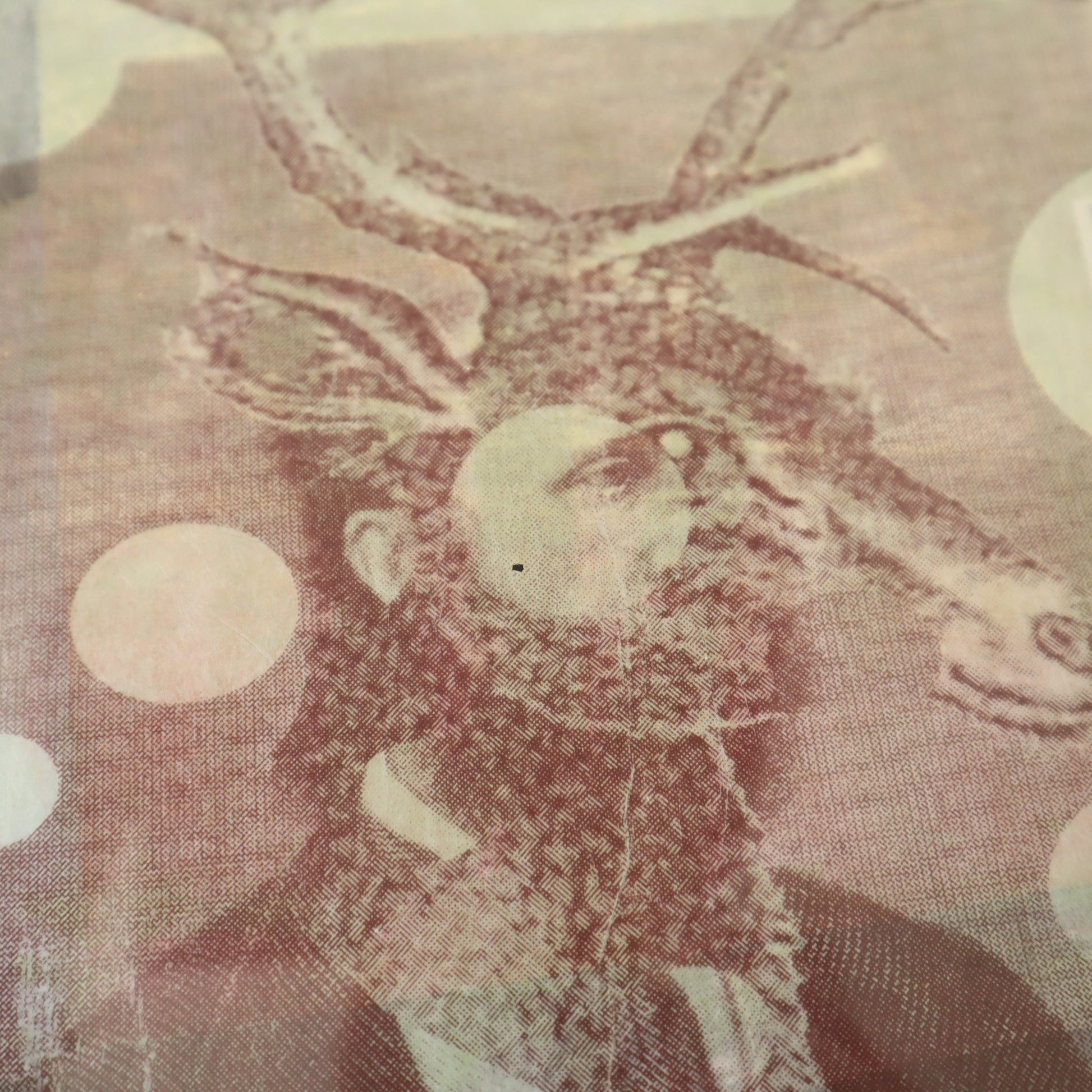 Decorative stag figure with antlers on a textured fabric background