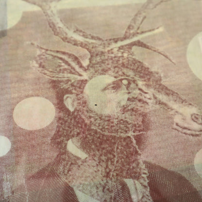 Decorative stag figure with antlers on a textured fabric background