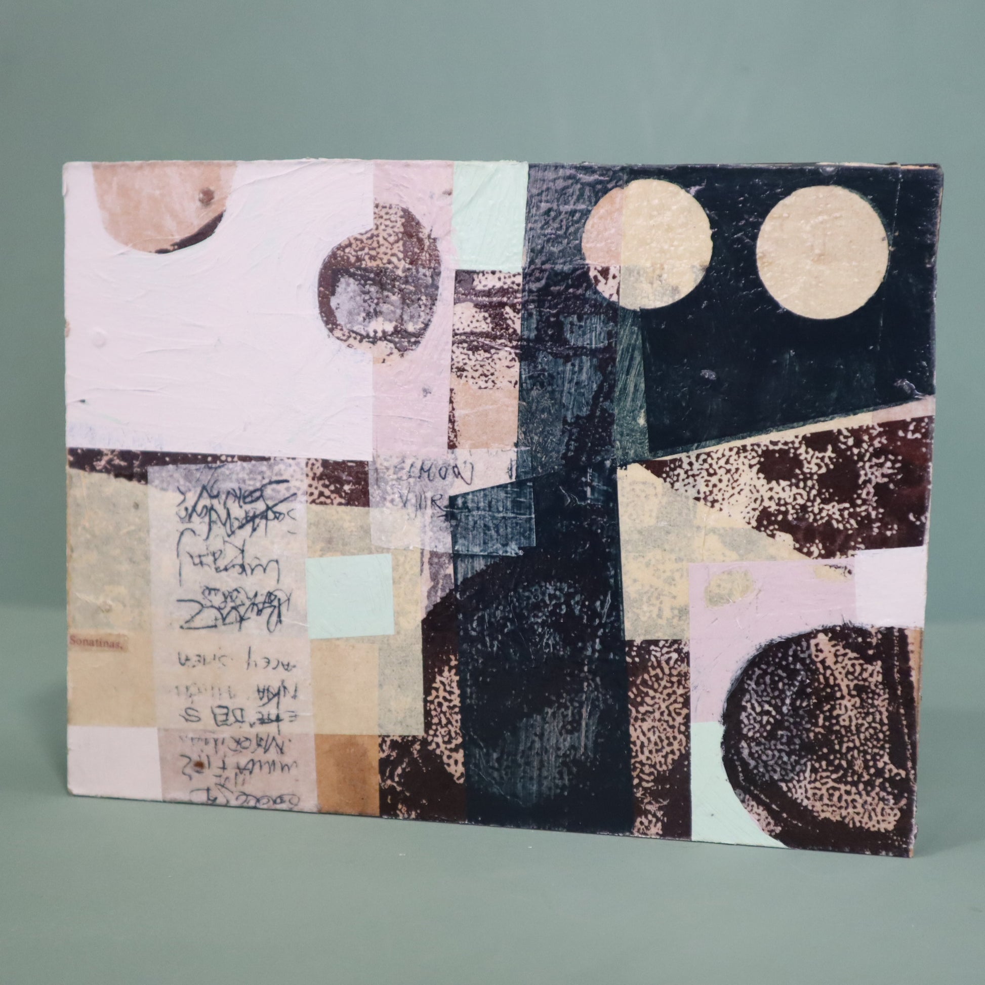 Abstract art piece with geometric shapes and text on a gray background