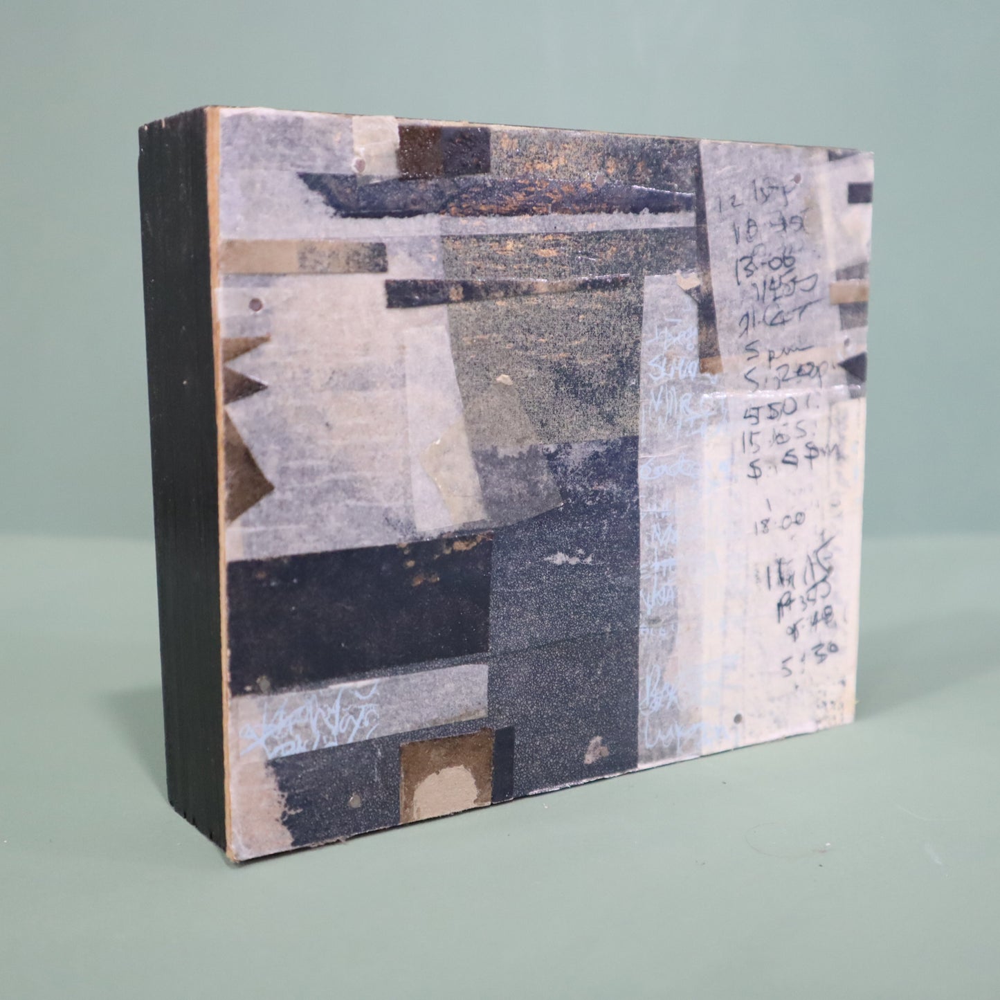 Square textured book with patchwork cover on a light green background