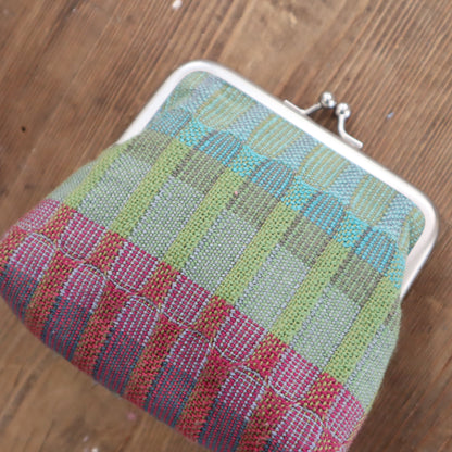 Colorful woven pouch on a wooden surface