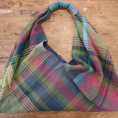 Hand woven shoulder bag on a wooden surface