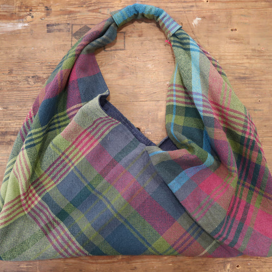 Hand woven shoulder bag on a wooden surface