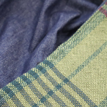 close up of a Hand woven bag, showing checked pattern of the outside of the bag and lain blue of the lining