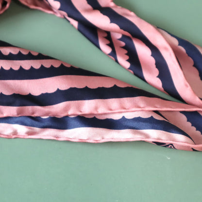 Pink and navy striped fabric on a green background
