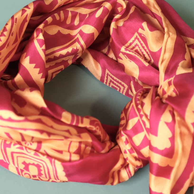 Red and orange patterned fabric on a gray background