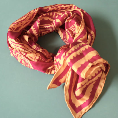 Red and orange patterned scarf on a light blue background