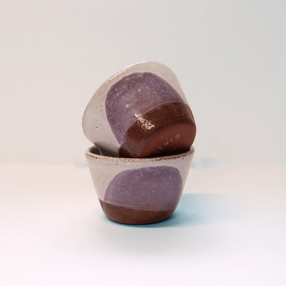 Two ceramic egg cups with purple and brown speckled design on a light grey background