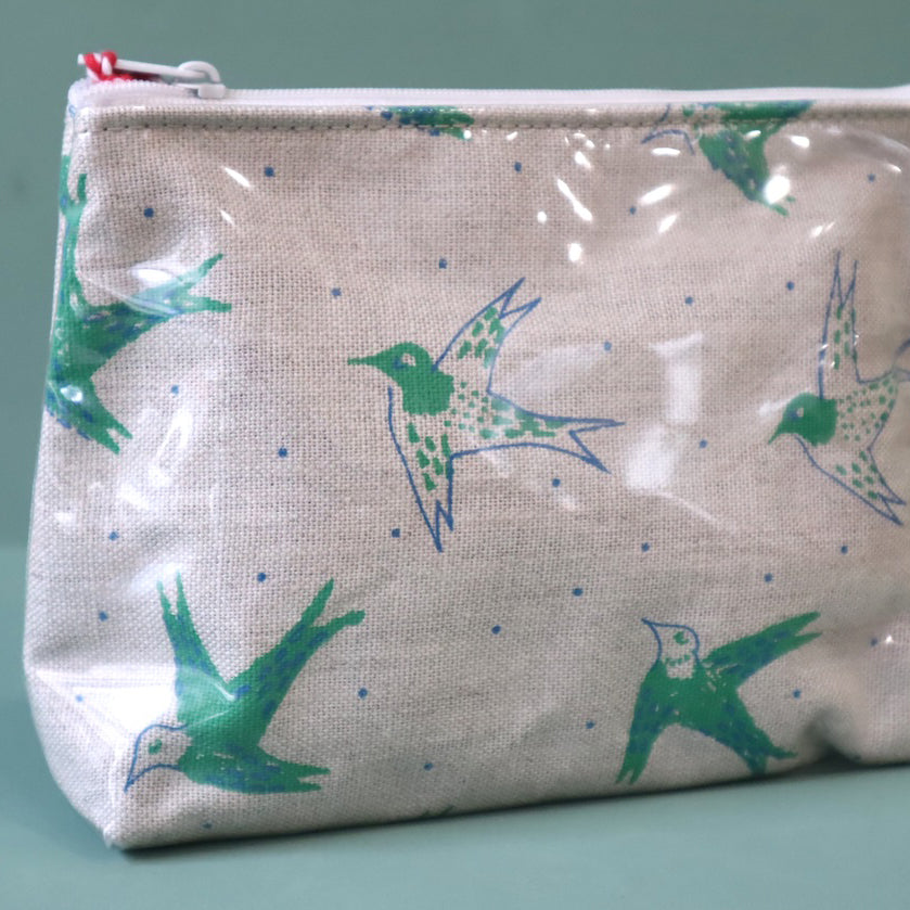 Linen washbag with plastic cover and a green  design of birds in flight. 