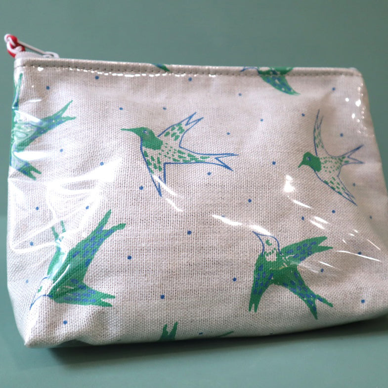 Linen washbag with plastic cover and a green  design of birds in flight. 