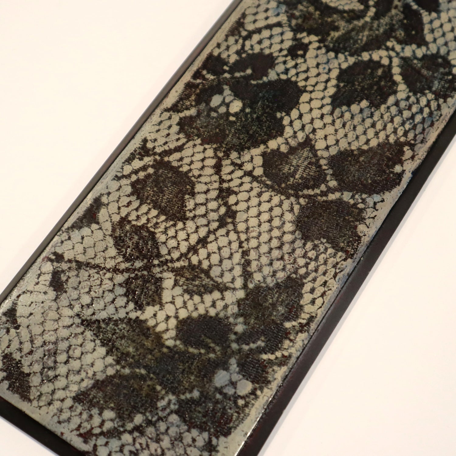 Close-up of a textured wall art with a lace pattern on a white background