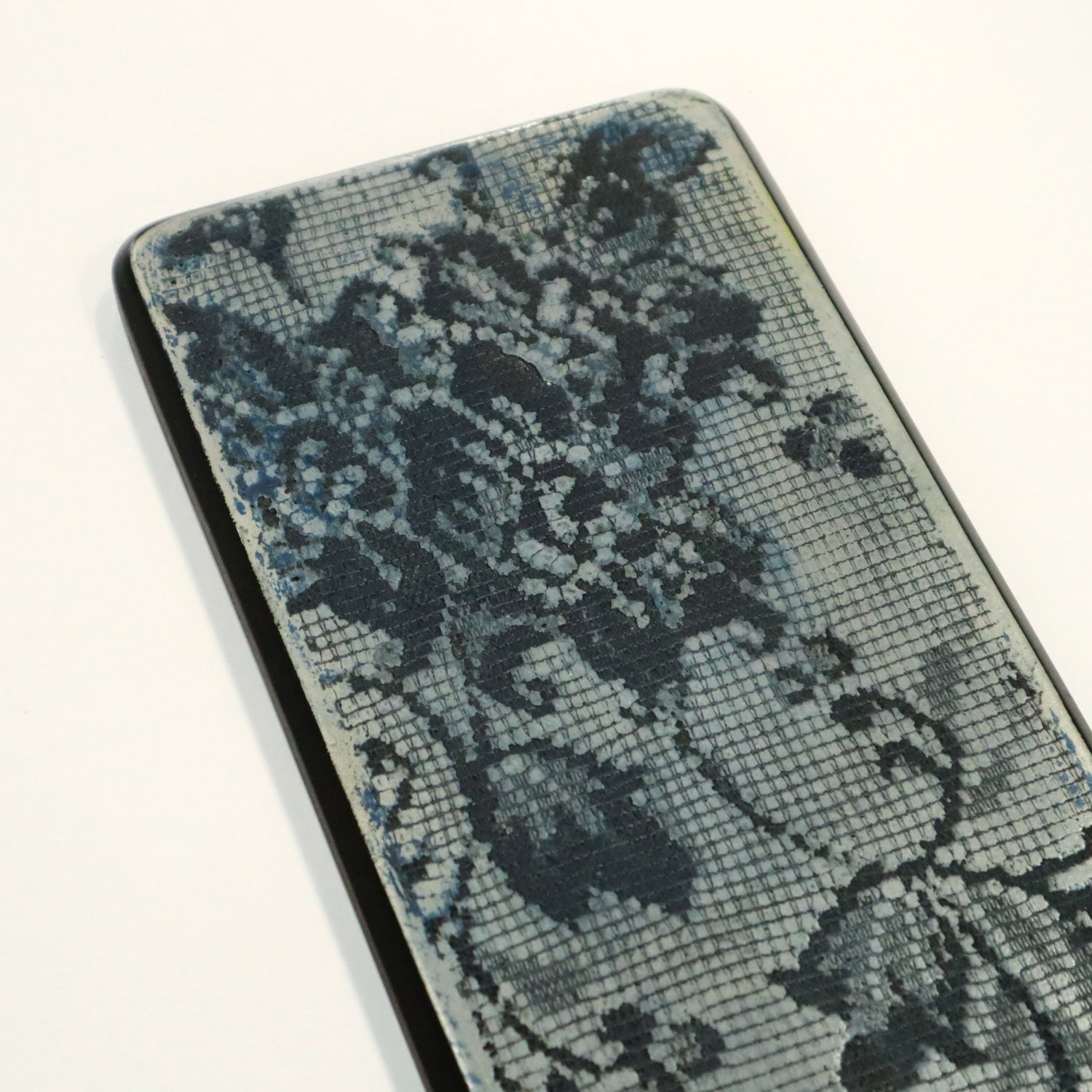Close up of floral lace imprinted into blue wall art