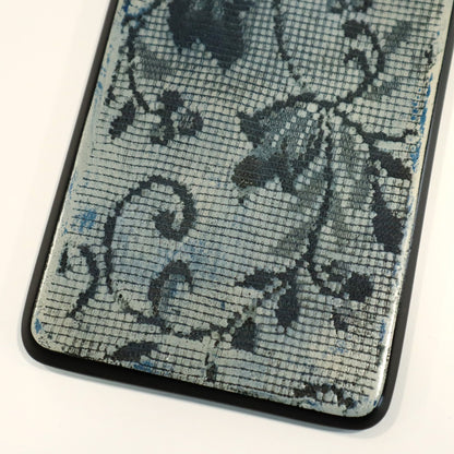 Close-up of a textured wall art with floral lace patterns on a white background