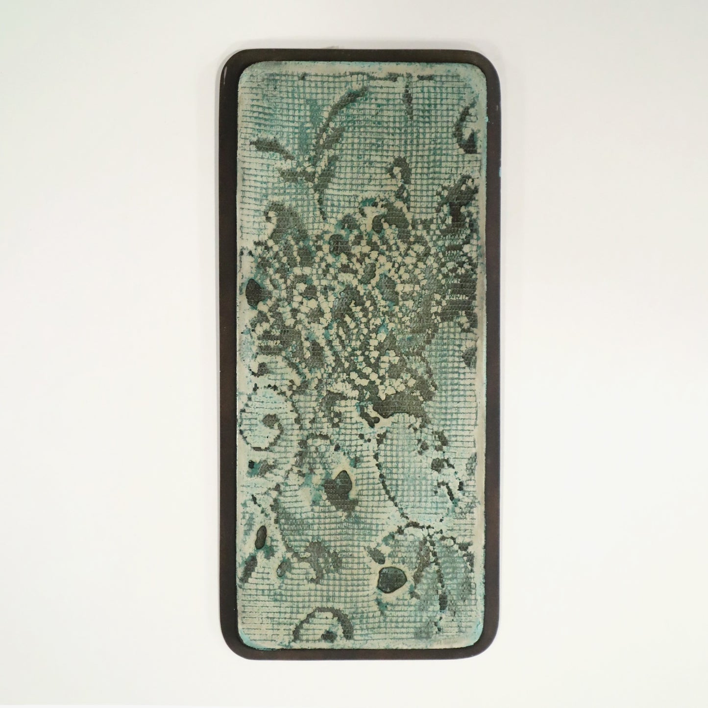 Wall art with green background and lace imprinted in on a white background