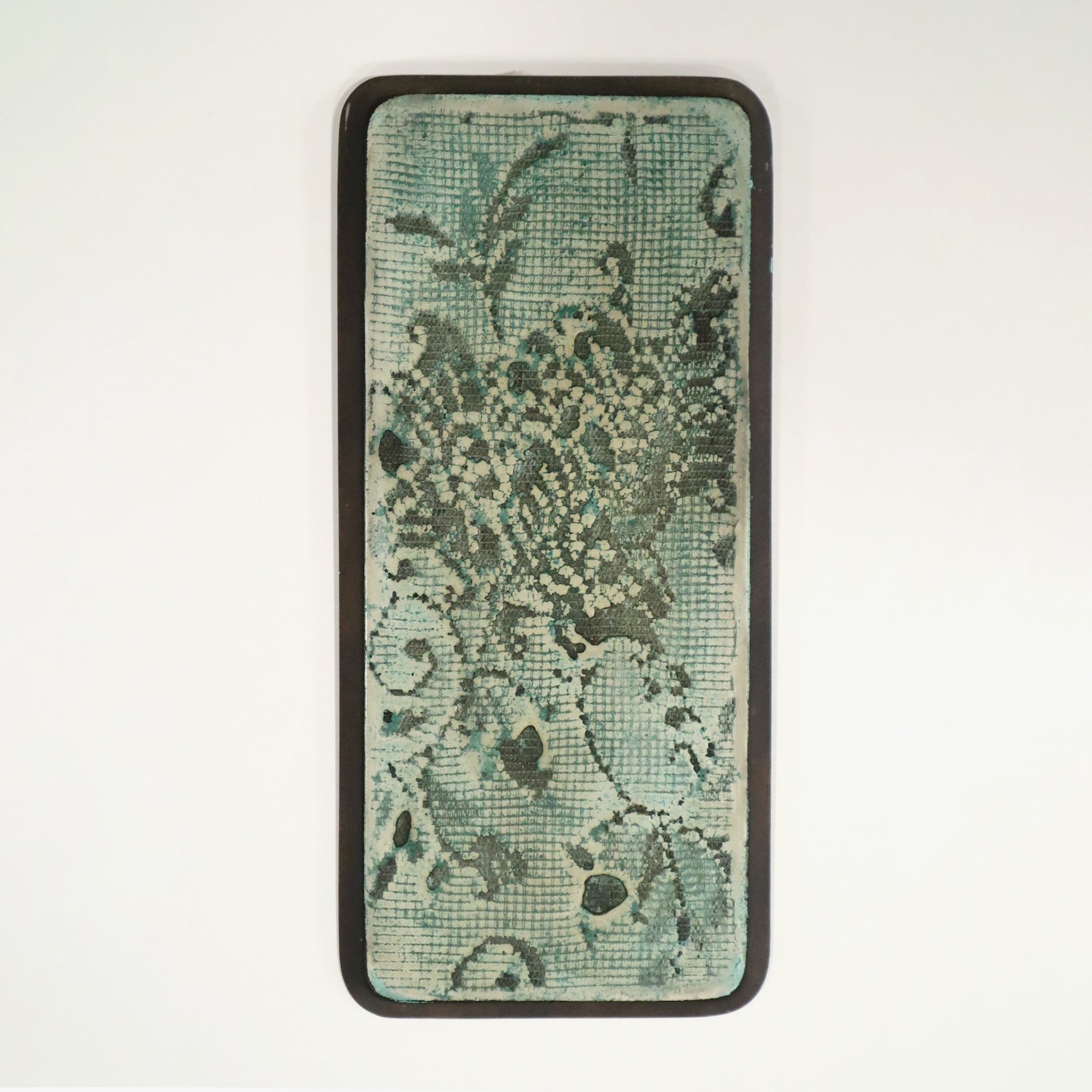Wall art with green background and lace imprinted in on a white background